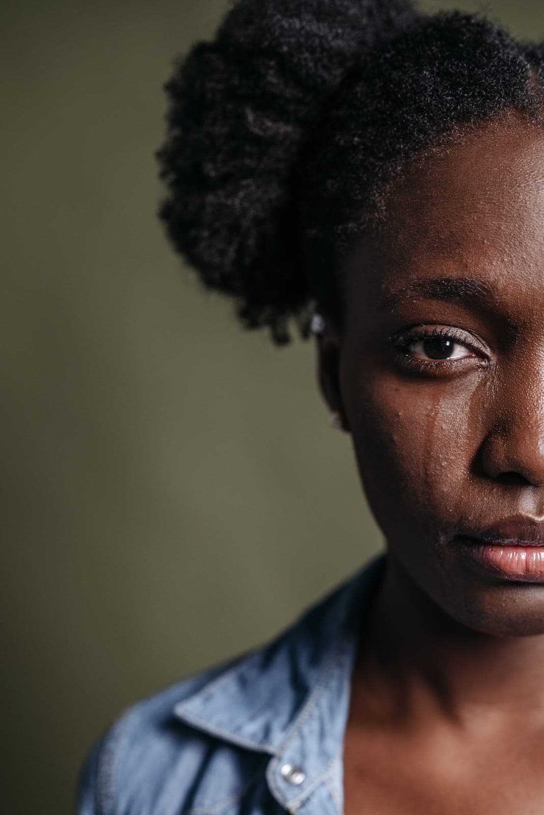 Close-up of a woman with a single tear running down her cheek
